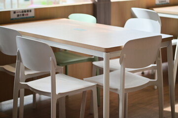 Clean Nordic-style indoor dining area featuring minimalist table and chair arrangement. Bright modern restaurant interior with Scandinavian design aesthetic for casual dining.