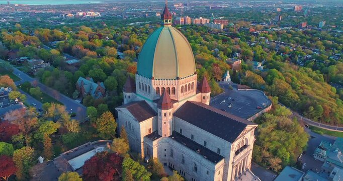 Saint Joseph's Oratory soars above Montreal, Canada, at sunset. The basilica is a major pilgrimage site, attracting visitors for its architecture and spiritual significance.