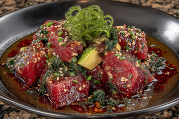 vibrant photograph of a colorful poke bowl with fresh raw fish, avocado, seaweed