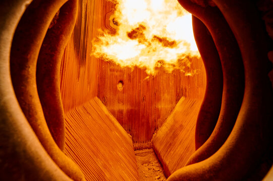 Intense flame combustion inside a steam boiler furnace at a thermal power plant showcasing heat exchange elements