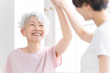 Fototapeta premium ヨガをする若い女性とシニア女性 健康イメージ