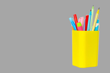 Colorful pens and pencils stand in a vibrant yellow holder