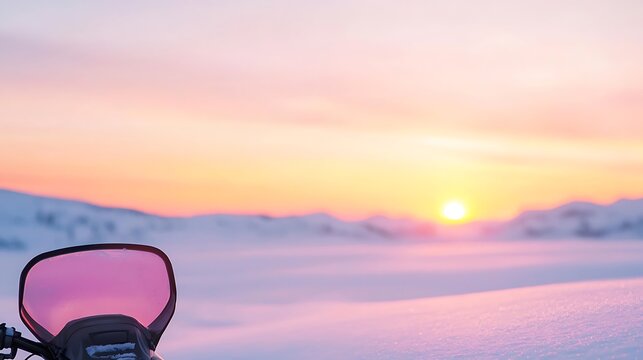 Snowmobile windshield reflects a pastel arctic sunset