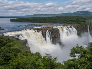 Fototapeta premium Powerful Waterfall Flowing Over Rocky Outcrops nature