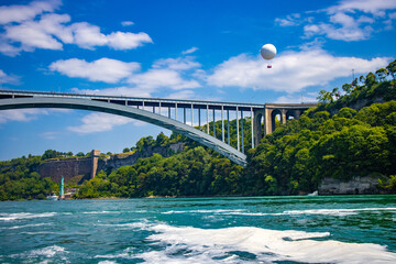 The gushing turquoise water from the Niagara falls with blue sky and white clouds the beautify scenry of nature