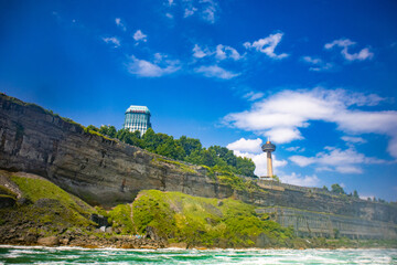 The gushing turquoise water from the Niagara falls with blue sky and white clouds the beautify scenry of nature