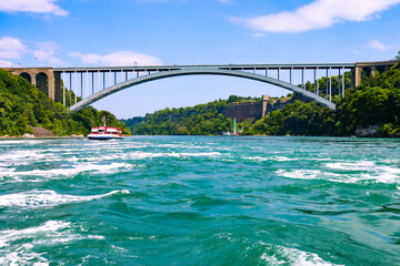 The gushing turquoise water from the Niagara falls with blue sky and white clouds the beautify scenry of nature