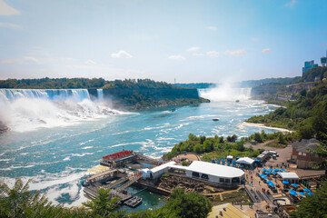 The gushing turquoise water from the Niagara falls with blue sky and white clouds the beautify scenry of nature