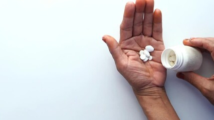 health of elderly person taking medicine pills closeup Senior hands medication vitamins supplement - Powered by Adobe