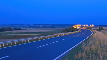 Scenic twilight drive on a winding country road with distant lights illuminating the horizon