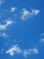 A vivid blue sky framed by thin, wispy white clouds forming a natural “cloud ring.” The clouds create an open window-like space in the center, giving the impression of a framed view of the sky.