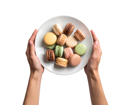 A person is presenting a white plate filled with an assortment of delicious macarons.