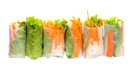 Fresh, vibrant spring rolls, filled with colorful vegetables and herbs, displayed in a horizontal arrangement against a stark black background.