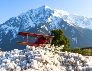 Red biplane atop snowy mountain