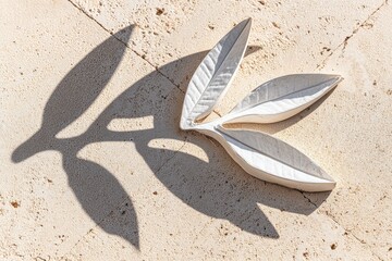 White relief leaves cast a shadow on light beige stone