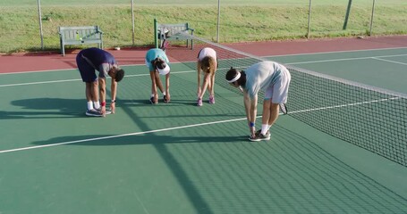 Responding to coach signal, Diverse tennis teammates holding forward bends on court with rackets - Powered by Adobe