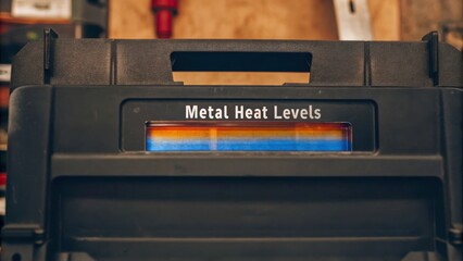 Metal heat levels indicator shows temperature readings in workshop setting, emphasizing importance of safety in vocational training