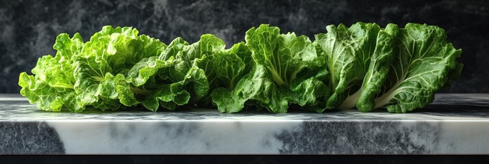 Fresh, vibrant green leafy vegetables arranged on a marble surface against a dark background
