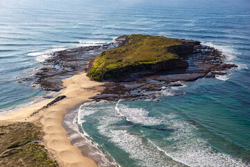 Windang Island is a prominent coastal feature located at the entrance to Lake Illawarra, just south of Wollongong on the Illawarra coastline. The island divides Warilla and Windang beaches. 