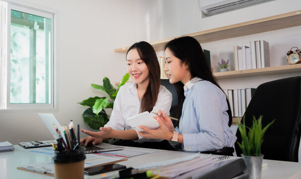 Teamwork. Young women collaborating on a digital project in a stylish office.