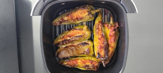 Large green chilies are deseeded and stuffed with seasoned minced pork and baked in an air fryer.