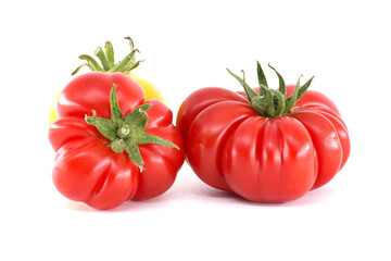 Three vibrant heirloom tomatoes are displayed against a clean white backdrop.