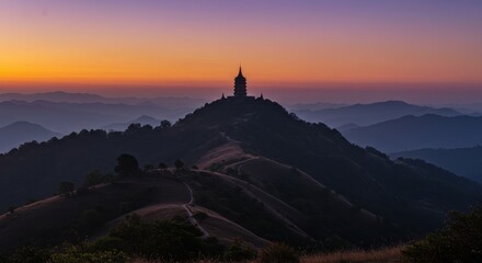 Obraz premium Serene Mountain Pagoda Silhouetted Against a Luminous Orange and Purple Twilight Sky
