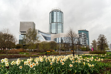 Obraz premium Colorful flowers in the foreground with the Yeltsin Center building in the background. A contrast of nature and modern architecture in Yekaterinburg, Russia.