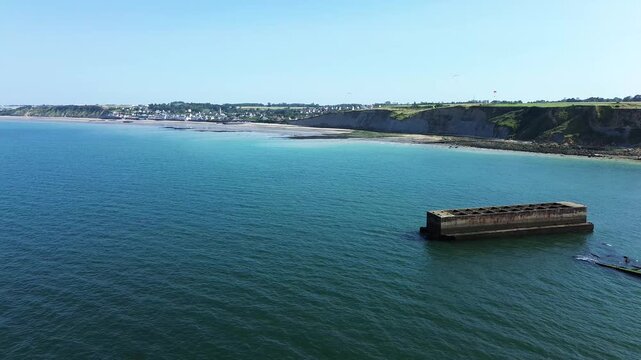 Aerial drone shot capturing the WWII Mulberry harbour remains at Arromanches