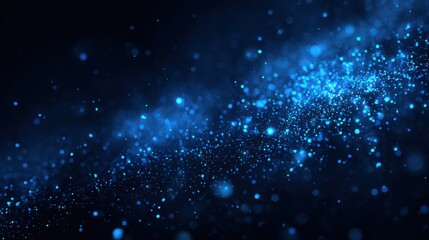Fototapeta premium A stunning display of blue particles fills the space, resembling stars in a vast night sky. The dynamic effect creates a sense of depth and wonder, engaging the viewer's imagination.