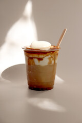 Einspänner coffee (Vienna coffee). Coffee topped with cream. Served in a clear disposable cup with a wooden stick.