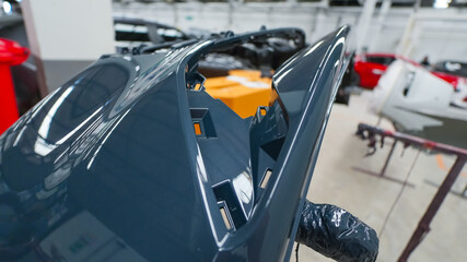 damaged car side skirt undergoing repaint after a heavy collision in an auto body workshop. Insurance repair process showing restoration, sanding, and painting to return the vehicle to its original
