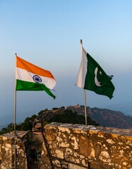 Flags of India and Pakistan waving atop a wall