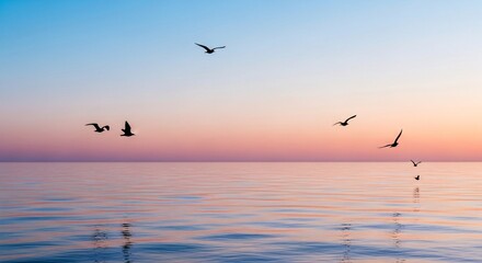 Fototapeta premium Silhouette seagulls soar over a calm, pastel sunrise ocean.