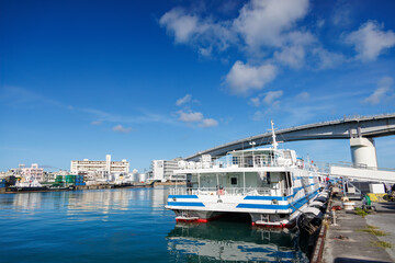 Fototapeta premium 慶良間諸島の渡嘉敷島へゆく高速ジェットフェリー。 マリンライナーとかしき。 奥には泊大橋が見える。 沖縄県那覇市那覇泊港-2025/6/27 沖縄の海の玄関口、那覇泊港。 慶良間諸島の座間味島等へゆく高速ジェットフェリー。 クイーンざまみ3号に乗船した。 