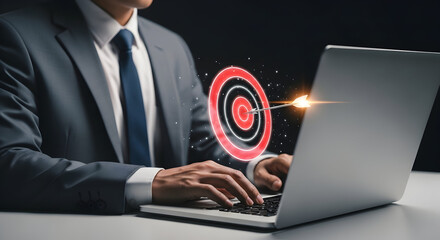 A businessman in a suit works on a laptop, aiming for success with a digital projected on the screen, representing goals and business strategy.