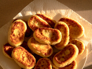 Golden brown homemade cheese patties cooling on paper towel