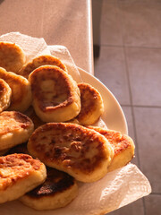 Freshly baked syrniki resting on kitchen counter in warm sunlight
