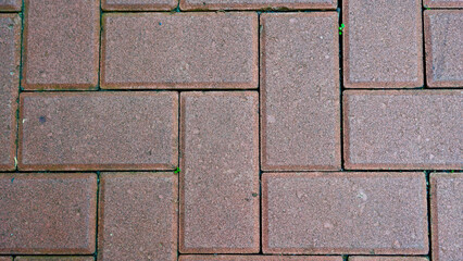 Close-up view of red paving blocks arranged neatly on the street, forming a strong and durable walking path