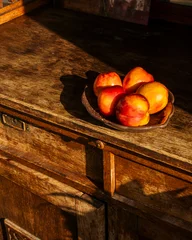 Fotobehang Fiets Ripe nectarines resting on a ceramic plate on an antique wooden cabinet  © Artem