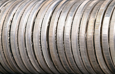 Reeded edges of silver coins, close-up, from above. Circulated silver bullion coins of one troy ounce of 99.9 percent pure silver each, also known as 999 fine silver, neatly arranged in a row. Photo