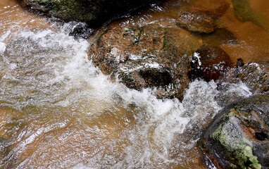 Water from the waterfall splashes against the rocks