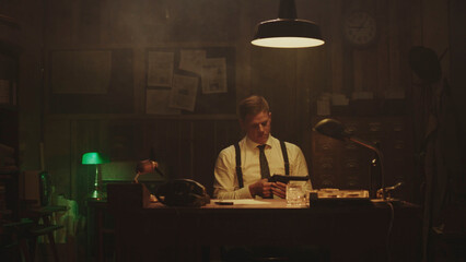 Detective examining gun in smoky office at night
