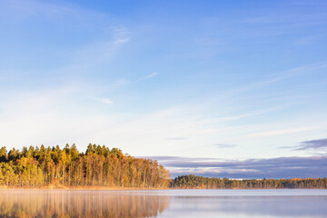 Glossy forest lake with water reflections at autumn