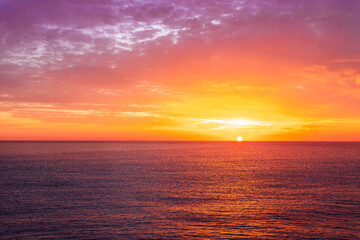 Fototapeta premium beautiful sunrise or sunset seascape with amazing calm sea water with waves and colorful amazing cloudy morning sky on background