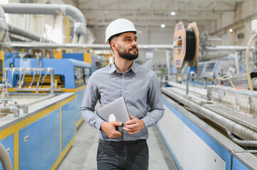 Industrial engineer walking and holding laptop in a factory