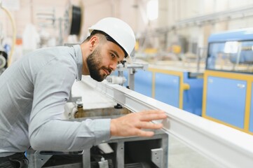 Engineer inspecting pvc window frame in factory