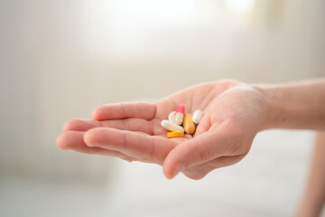 Close-up of mom-to-be hand holding prescribed pill while protecting her belly. Responsible approach to treatment during sensitive pregnancy period.