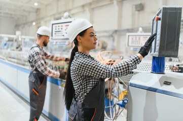 Fototapeta premium Female engineer operating machinery in modern factory