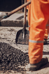 Naklejka premium Construction workers working on a new asphalt layer on a public street.